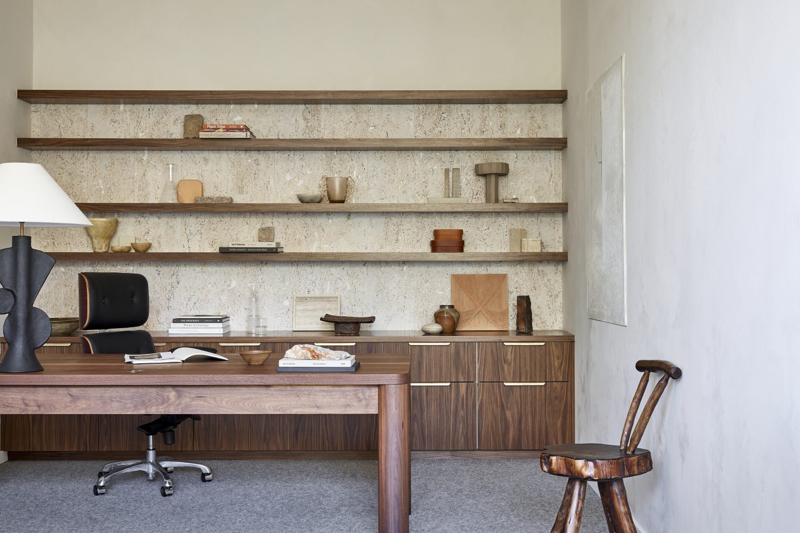 Office of creative director Anthony Wyer, of Wyer &Co. Architecture by Daniel Boddam, interior objects from Tigmi trading. A desk with a chair and shelves in neutral office palate.