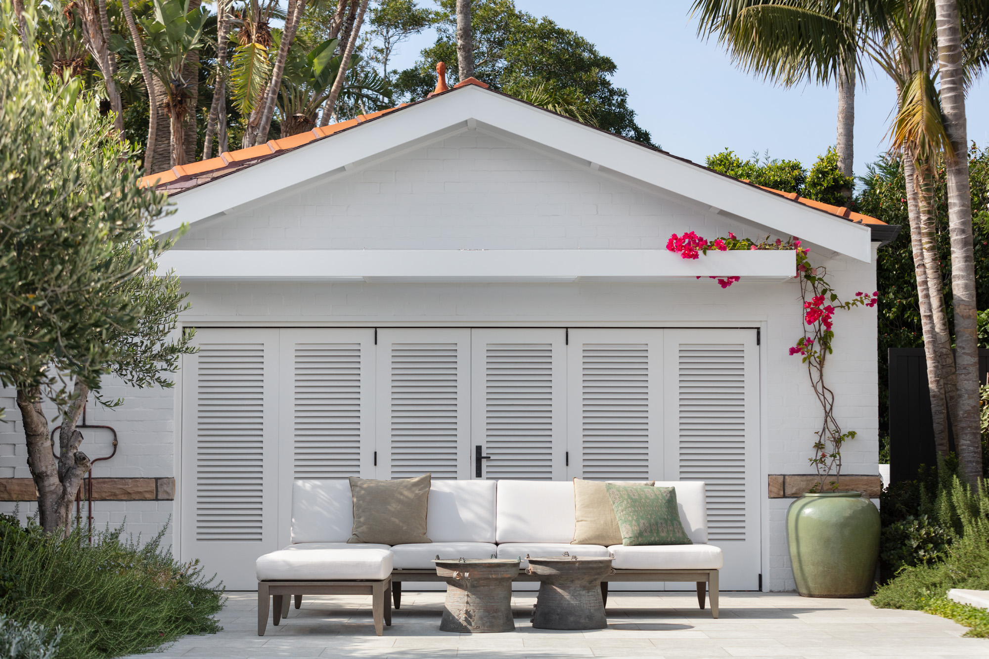 Poolside cabana with handcrafted timber bifold doors features Bougainvillea accent.